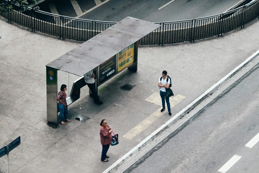 An aerial view capturing people waiting at a bus stop in a city setting.