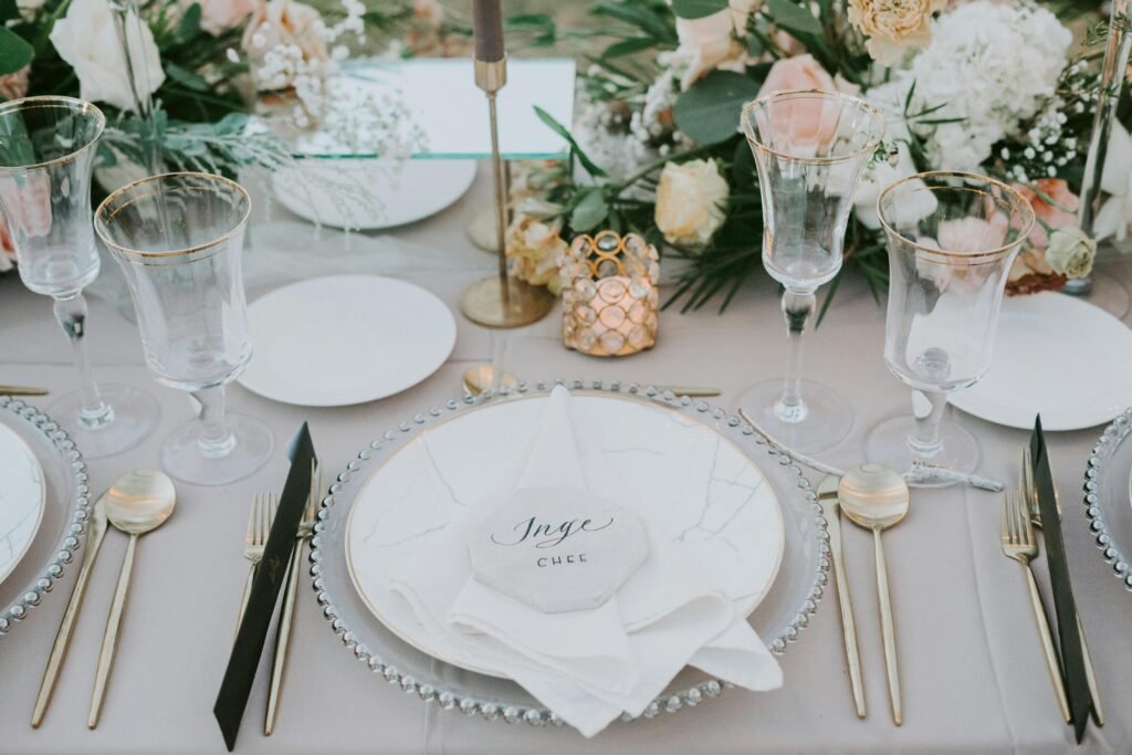 Sophisticated table setting with luxurious tableware and floral decoration at a wedding event.