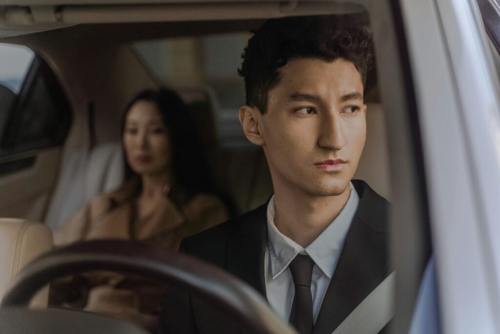 Well-dressed individuals in car interior, reflecting calm and elegance.