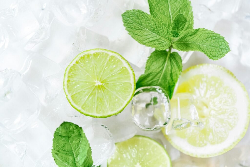 High angle view of lime slices and mint leaves on ice, perfect for refreshing drink concepts.