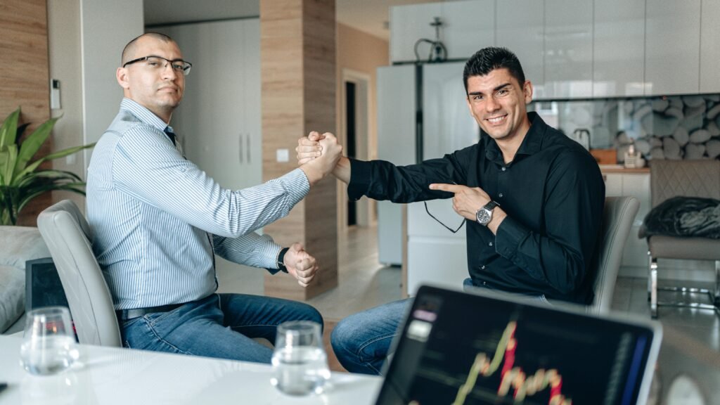 Two businessmen sealing a deal with a handshake in a modern office setting.